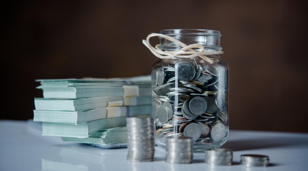 bottles-cash-with-coins-saving-money-concept (1)